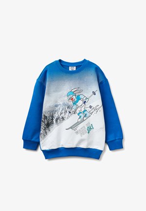 Sweat-shirt bleu avec un lapin de dessin animé en train de skier, portant des lunettes et un équipement, descendant une pente enneigée, avec le texte "WAKE UP FOR Ski."