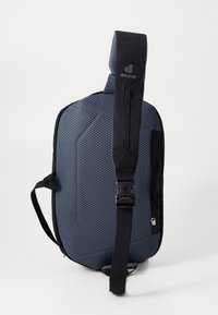 Blue and black backpack with a textured, geometric material, adjustable strap, and side pockets. Features durable hardware and a streamlined shape.