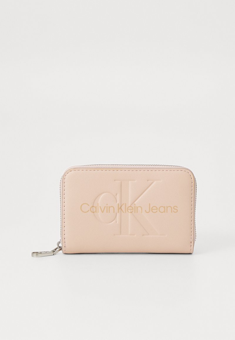Rožinė dirbtinė odinė piniginė su iškilniu "CK" logotipu ir "Calvin Klein Jeans" tekstu, su užtrauktuku ir sidabro spalvos detalėmis.