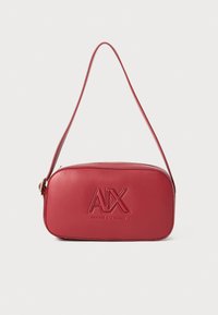 Raudona odinė rankinė petneišai su iškilniu "AIX" logotipu. Yra apvalios stačiakampės formos, su viena petneša ir lygiu paviršiumi. Uždarymas su užtrauktuku.