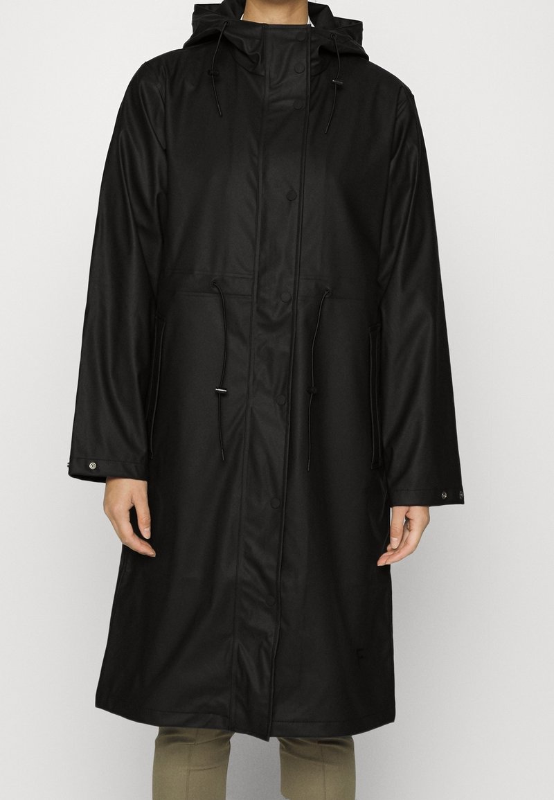 Impermeable negro con capucha, cintura ajustable con cordón y botones de presión. Presenta mangas largas y una textura suave y resistente al agua.