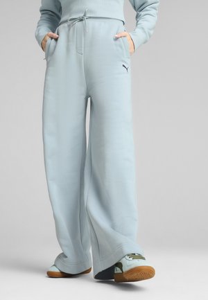 Lichtblauwe wijde sweatpants gemaakt van zachte stof, met een tailleband met trekkoord en zijzakken, voorzien van een klein zwart logo op het been.