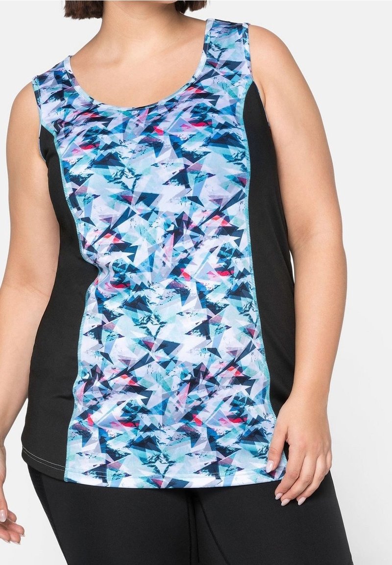 Femme portant un haut de sport sans manches avec un motif géométrique abstrait bleu, noir et rose, associé à un pantalon noir.