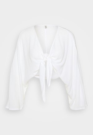 Biała krótka bluzka z głębokim dekoltem w kształcie V i luźnymi rękawami, z wiązanym przodem i teksturowanym materiałem. Idealna do noszenia na co dzień.