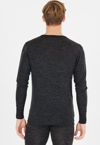 Zwart mannen langetermijn shirt, gemaakt van gebreide stof, met een ronde hals en een aansluitend ontwerp met lange sleeves en een gladde textuur.