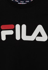 T-shirt in cotone nero con un grande logo "FILA" bianco con un accento rosso, maniche corte e scollo rotondo con colletto marchiato.