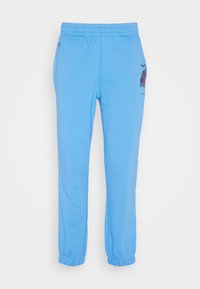 Light blue elastic-waist jogger pants with elastic cuffs and a small dark red graphic on the upper right thigh.