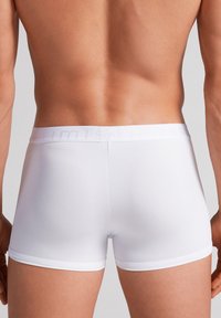 Hvide boxer underbukser lavet af et glat, strækbart stof. Har en blød elastisk talje med prægede logoer. Tæt siddende design.