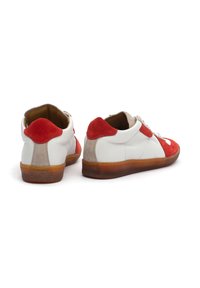 White leather sneakers with red suede accents, beige detailing, and a tan rubber sole. Features a rounded toe and lacing system.