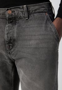 Grijze denim jeans met een zachte textuur, vijf-pocket ontwerp en metalen hardware bij de taille. Voorzien van contrasterende stiksels en subtiele vervaging.