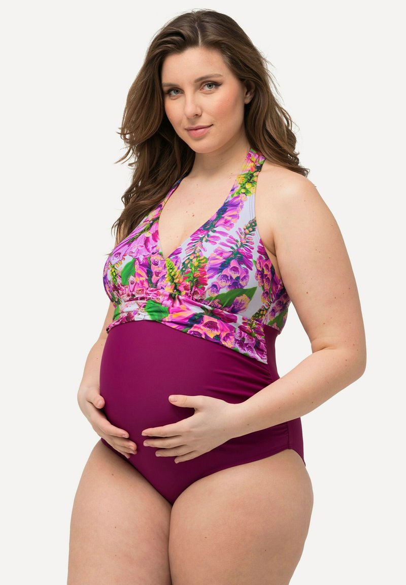 Těhotenské plavky s květinovým vzorem nahoře v purpurové a zelené barvě, a jednobarevné bordó dno. Design za krk, podpůrné sezení, hladký povrch.
