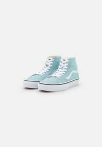 Adidași înalți din suede bleu deschis, cu șireturi albe, talpă din cauciuc negru și design clasic cu dungi laterale. Detaliu perforat pe zona degetelor.