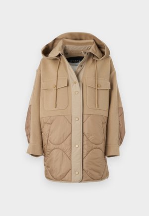 Veste beige à capuche avec une partie inférieure matelassée, deux poches poitrine et des cordons de serrage. Le matériau combine un tissu lisse et une texture douce.