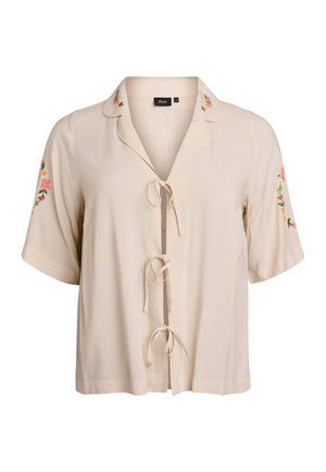 Beige Bluse mit kurzen Ärmeln und Kragen, dekorativer Stickerei an den Ärmeln und einer Bindung vorne. Glatte Stoffstruktur.