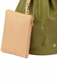 Borsa a secchiello verde in pelle con una tasca zip staccabile rosa chiaro. Accenti in hardware dorato sono visibili, migliorando il design.