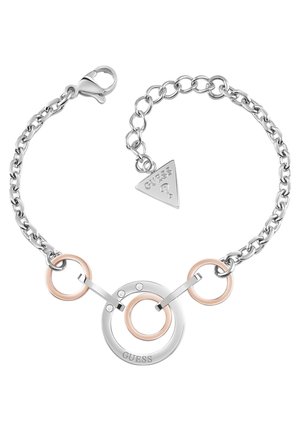 Zilveren en roségouden kettinkarmband met ronde schakels, kristallen accenten en een kleine driehoekige bedel met de gravure "GUESS".