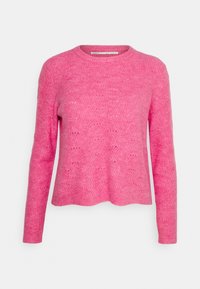 Rosa stickad tröja med rund halsringning, långa ärmar och ett texturerat mönster med små öppna stygn. Sjömanshamnen är något krökt.