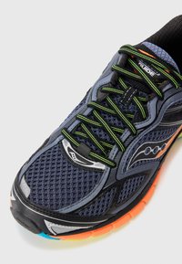 Men's athletic shoe; mesh upper in navy blue and gray with lime green laces. Black rubber outsole with orange and turquoise accents.