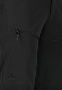 Zwarte performance shorts met een ritssluiting pocket en een gestructureerde afwerking. Inclusief een subtiel logo in de onderste hoek met driehoek accenten.