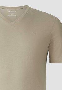 Beige T-shirt met korte mouwen en V-hals van katoen, met het s.Oliver-logo geborduurd op de borst en geprinte merkdetails in de kraag.