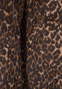 Leopardų rašto audinys, turintis minkštą, tekstūruotą paviršių su rudos ir juodos spalvų atspalviais, demonstruojantis abstraktų gyvūnų raštą.