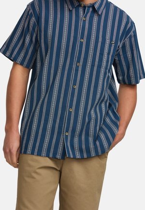 Chemise à manches courtes de couleur bleu marine, avec des rayures verticales blanches au motif subtil, fermeture à boutons à l'avant et une poche poitrine.