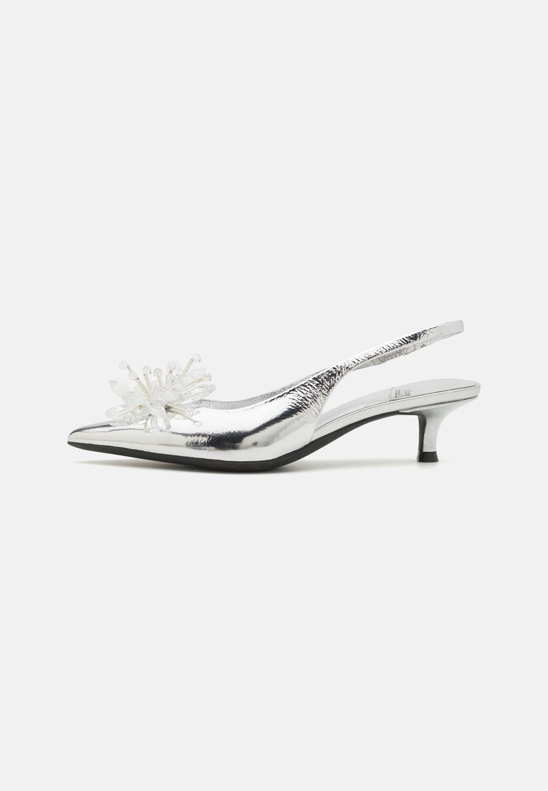 Srebrni slingback čevlji z ostrim nosom, teksturirano kovinsko zaključek in dekorativna prozorna kristalna okrasitev spredaj.