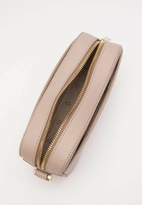 Pochette zip in pelle beige con hardware dorato, dotata di due scomparti con zip e una superficie liscia. L'interno presenta una fodera con motivo.