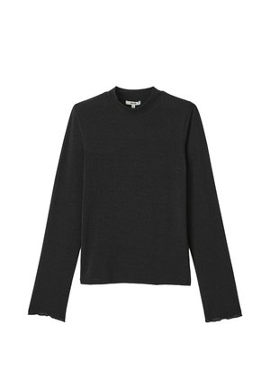 Haut noir à manches longues avec un col rond. Fabriqué à partir d'un tissu doux et texturé. Bords à volants notables aux poignets et à l'ourlet.