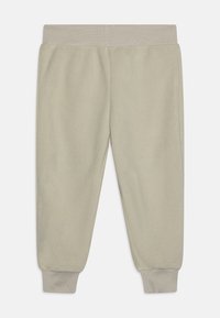 Fleece sweatpants in light green with a soft texture, featuring a ribbed waistband and cuffs for a snug fit.