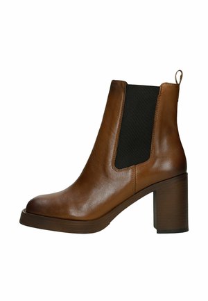 Stivale alla caviglia in pelle marrone con tacco a blocco e pannello laterale elastico nero, dotato di un tirante sul retro.