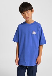 Blå t-shirt med korta ärmar i bomull med rund halsringning och en liten persikofärgad logga på bröstet. Avslappnad passform, slät textur.