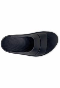 Czarne klapki z gładką, teksturowaną wkładką, szerokim paskiem na górze i prostą, ergonomiczną formą. Widoczne logo Oofos.