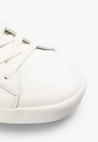 Weißes Leder-Sneaker mit flachen Schnürsenkeln, runder Zehenform und strukturiertem Gummisohle. Minimalistisches Design mit tonalem Nähen und nahtlosen Akzenten.