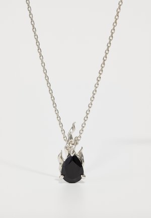 Pendentif en pierre précieuse noire en forme de goutte, entouré d'un design argenté évoquant des flammes, attaché à une chaîne en argent.