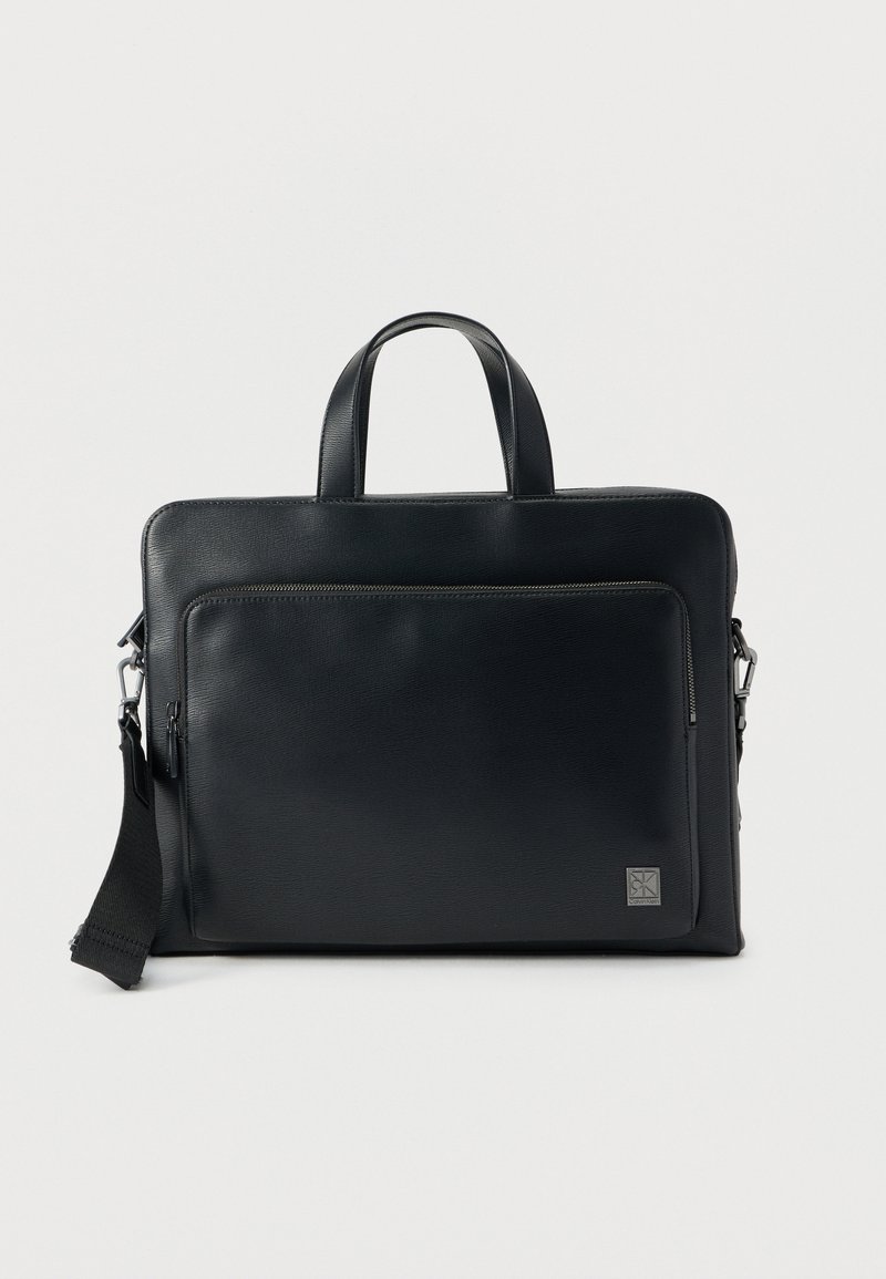 Μαύρη δερμάτινη τσάντα για φορητό υπολογιστή με διπλές λαβές στην κορυφή, ρυθμιζόμενο λουρί ώμου, εμπρόσθια τσέπη με φερμουάρ και υφή φινιρίσματος. Διαθέτει λεπτομέρεια λογότυπου στο κάτω μέρος.