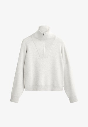 Svetlo siva majica s visokim ovratnikom, koja sadrži polu-zip i rebrastu teksturu. Kutni kroj s spuštenim ramenima i strukturiranim dizajnom.