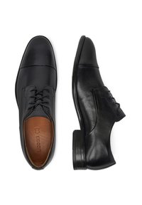 Mustad mustad jalatsid mustast nahast, sileda viimistlusega, terava toe, peenikeste paeltega ning õrnu kontrastset pruunist sisetalda. Madal ja kokku kuhjatud konts.