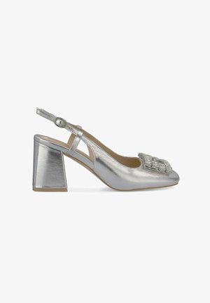 Sandal con tacco a blocco in metallic silver, punta quadrata e decorazione a gemma sulla parte frontale. Superficie liscia e lati aperti.