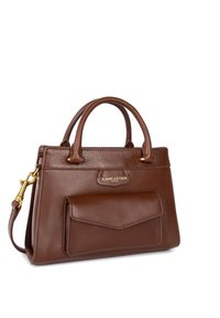 Sac à main en cuir marron avec deux poignées, rabat de poche avant, quincaillerie dorée et bandoulière amovible, logo Lancaster Paris visible.