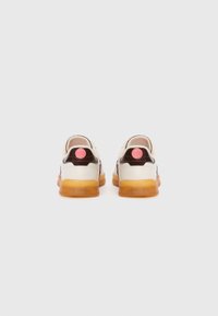 Sneakers med hvit og brun overdel, kremfargede detaljer, og gummifarget såle; har et rosa logo-patch på hælen.
