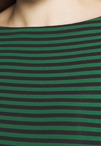 Grön och svart randig skjorta, tillverkad av ett mjukt, elastiskt material med en bred ringning och jämna horisontella linjer genom hela.