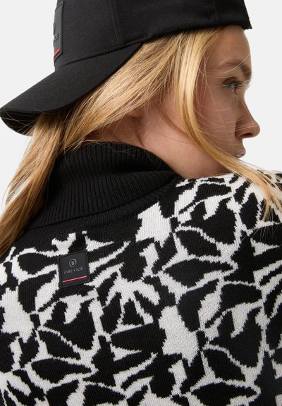 Πλεκτή μαύρη και λευκή ζακέτα με floral μοτίβο, ψηλό ριμπ γιακά και ετικέτα λογότυπου στο πίσω μέρος κοντά στον λαιμό.