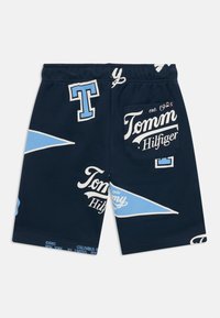 Marine bomullshorts med hvite og lyseblå grafiske trykk, inkludert "Tommy Hilfiger" og trekantdesign, med elastisk midje.