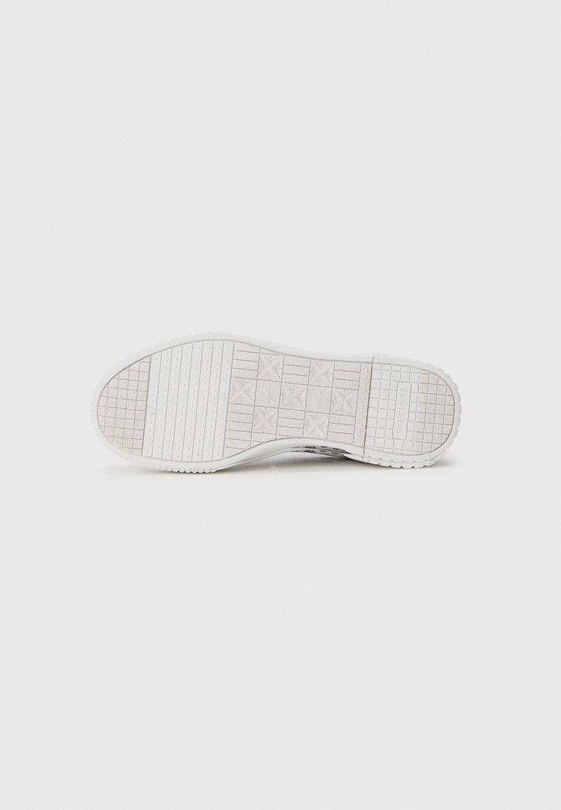 Semelle d'une chaussure de sport blanche avec un motif de semelle, comprenant des motifs en grille, des étoiles et des rainures, positionnée sur un fond blanc uni.