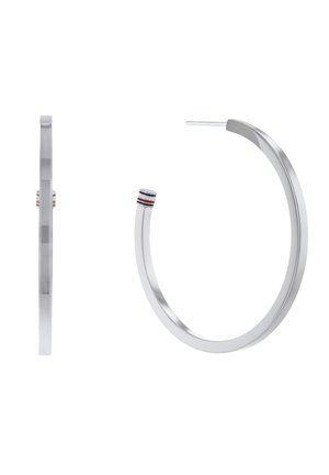 Grandes boucles d'oreilles anneaux ton argent avec bords plats et un petit détail rayé près du fermoir en bleu, blanc et rouge.