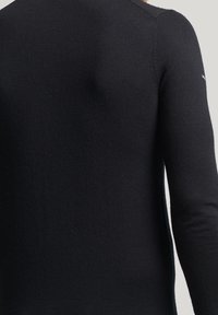 Schwarzer Strickpullover mit langen Ärmeln und strukturiertem Finish. Der Rücken zeigt ein glattes, nahtloses Design mit minimalen Details.