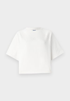 Camiseta blanca de gran tamaño con mangas raglán cortas, hecha de una tela suave. Presenta un logotipo sutil en el pecho y un escote redondo.