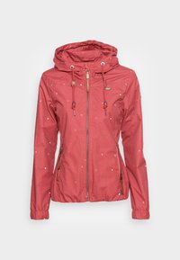 Red waterproof jacket with a hood, featuring white dot patterns and zippered pockets. Drawstrings and wooden accents enhance the design.