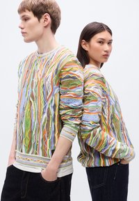 Πλεκτό πουλόβερ με έντονα, πολύχρωμα σχέδια σε πράσινο, πορτοκαλί, κίτρινο και μπλε, με ριμπ μανσέτες και τελείωμα· άνετη εφαρμογή.